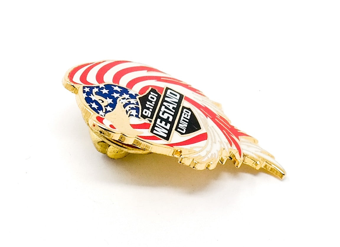 9/11 September 11, 2001 Collectible Commemorative Lapel Pin with an eagle designed with red, white, and blue American flag details, with the words "9.11.01 We Stand United" in a black banner.